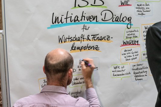 Moderator der Veranstaltung beschriftet das Flipchart