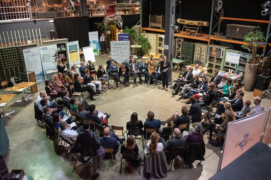 Teilnehmer sitzen in doppeltem Kreis bei der Veranstaltung 