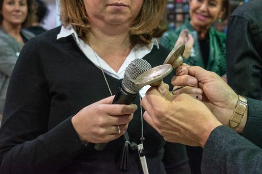 Moderatoren der Veranstaltung benutzen Klangelemente und ein Mikrofon um die Teilnehmer zur Pause zurück zu holen