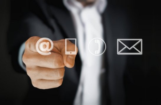 Bild das eine Kontaktmöglichkeit illustriert. Hand die auf die Symbole E-Mail, Telefon und Adresse zeigt.