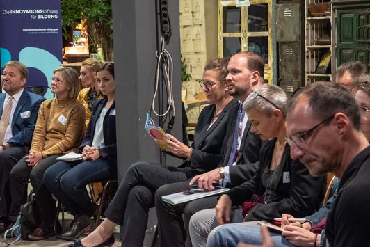 Teilnehmer im Sesselkreis sitzend