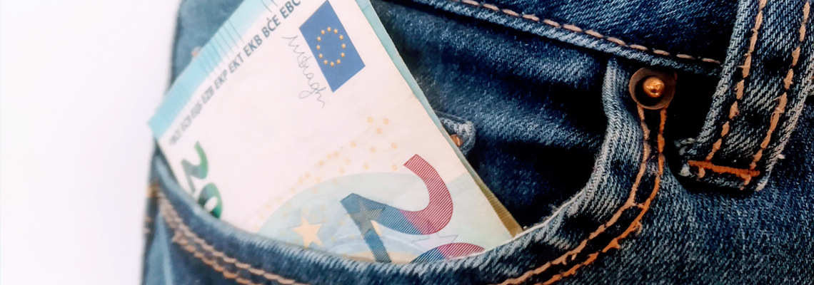 ein Zwanzig Euro Schein schaut halb aus einer Jeans-Hosentasche